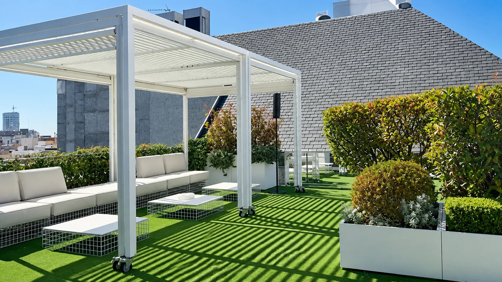 Pérgola blanca instalada por Racu Reformas en una terraza ajardinada con zona de estar
